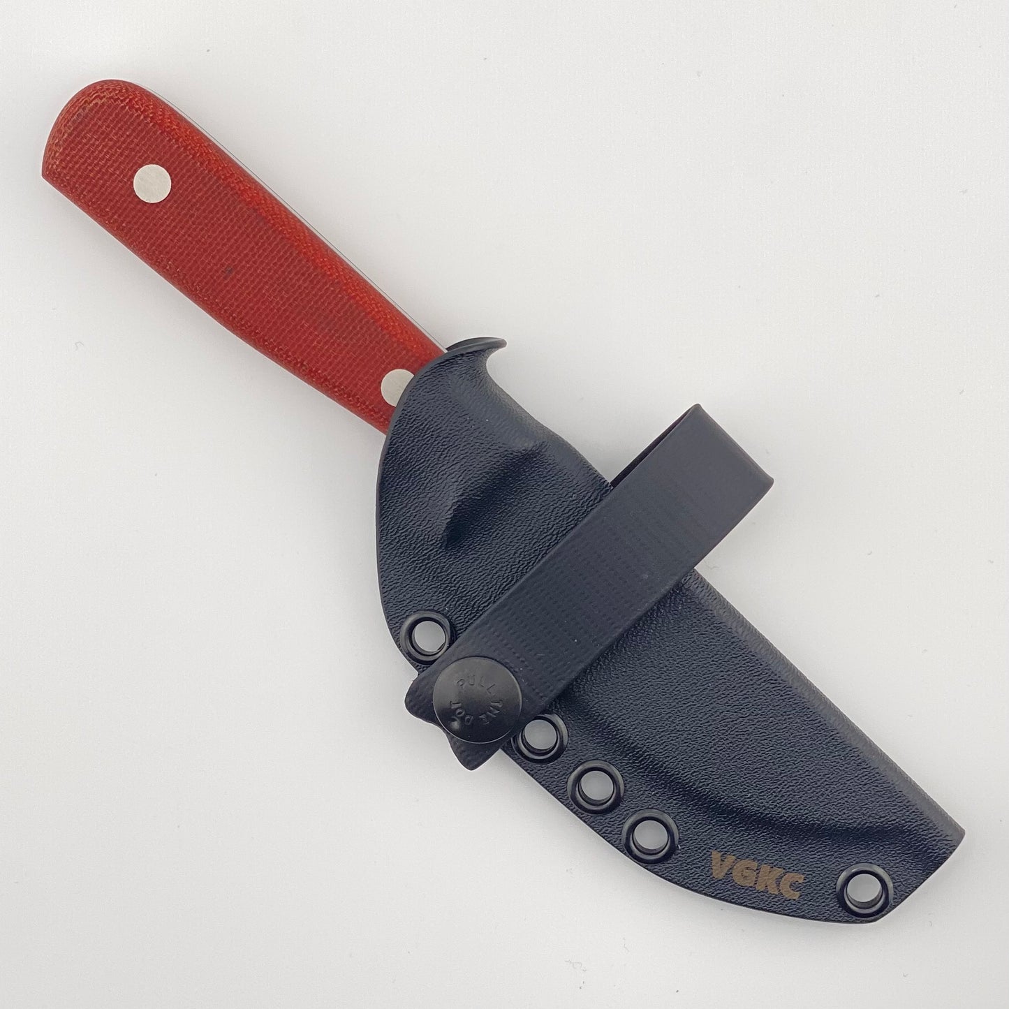 Black knife sheath with red handle on a white background