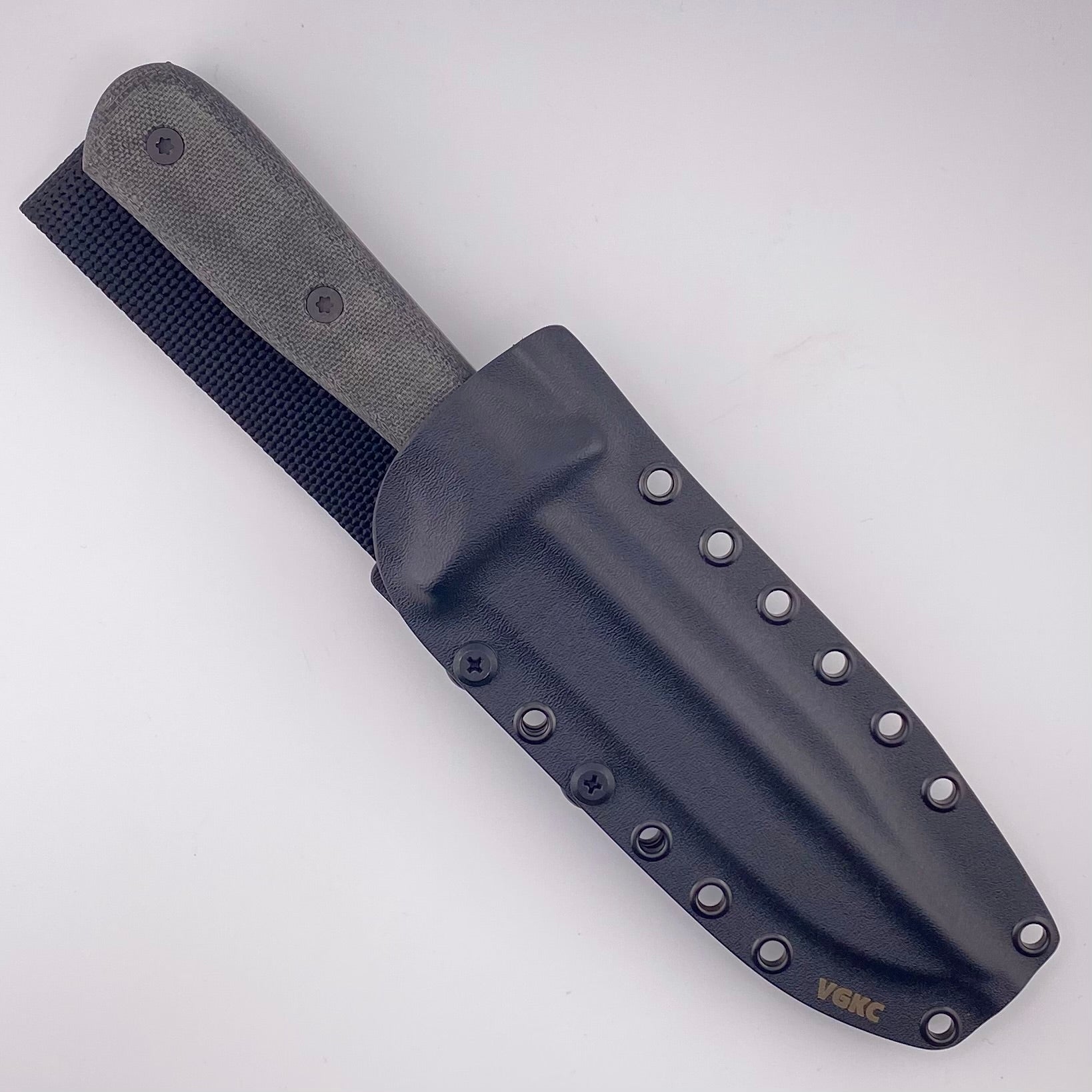 Black textured handled knife in a balck sheath on a white background