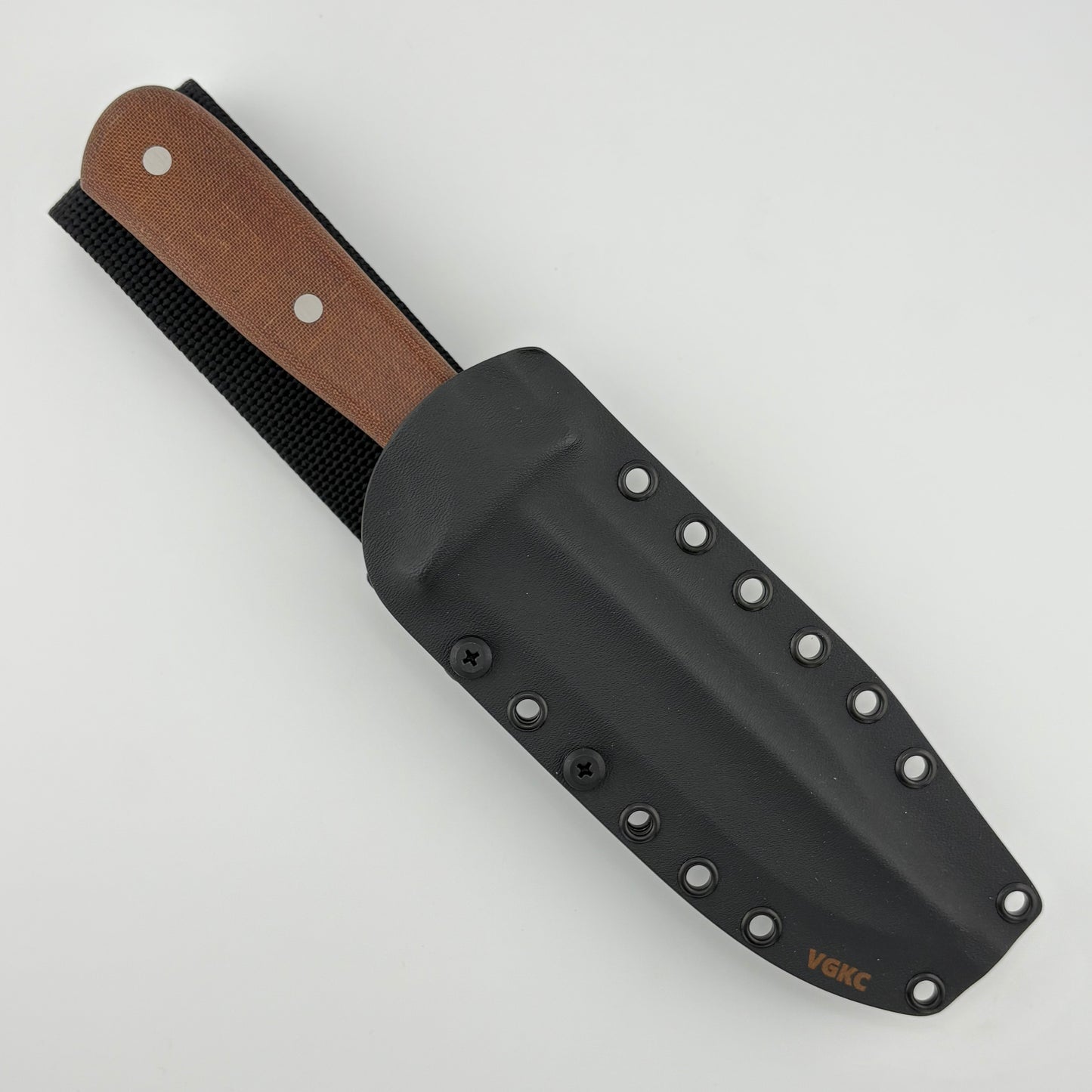 Black sheath with brown handle knife on a light gray background