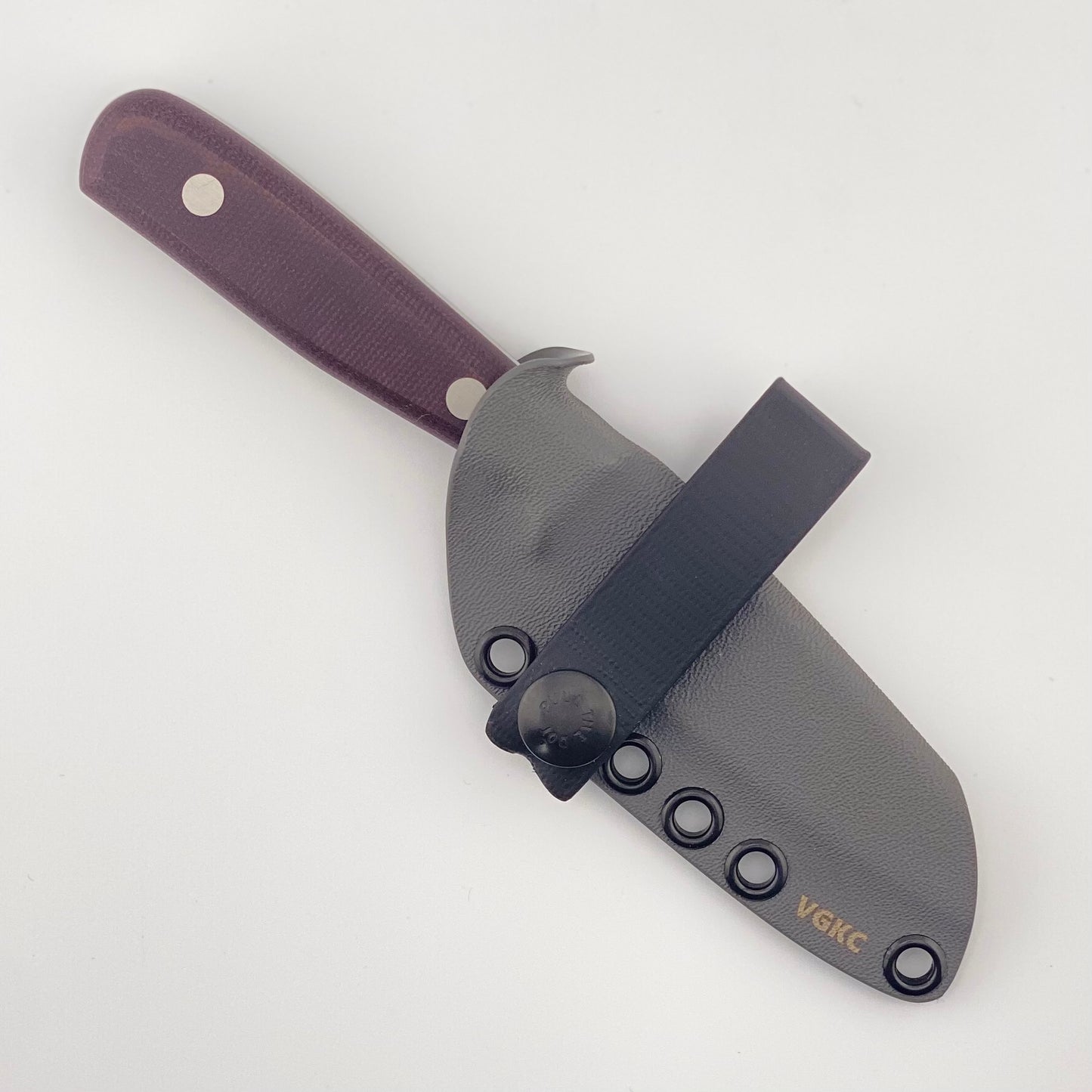 Knife with a purple handle in a gray sheath on a white background