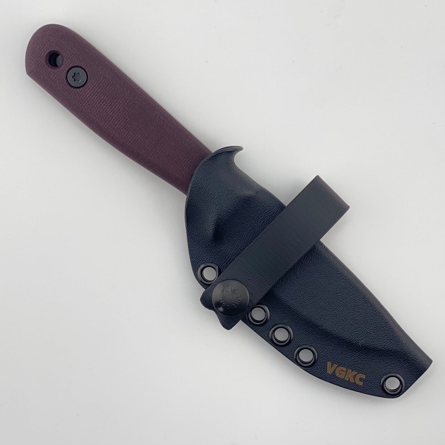 Knife with purple handle in a black sheath on a white background