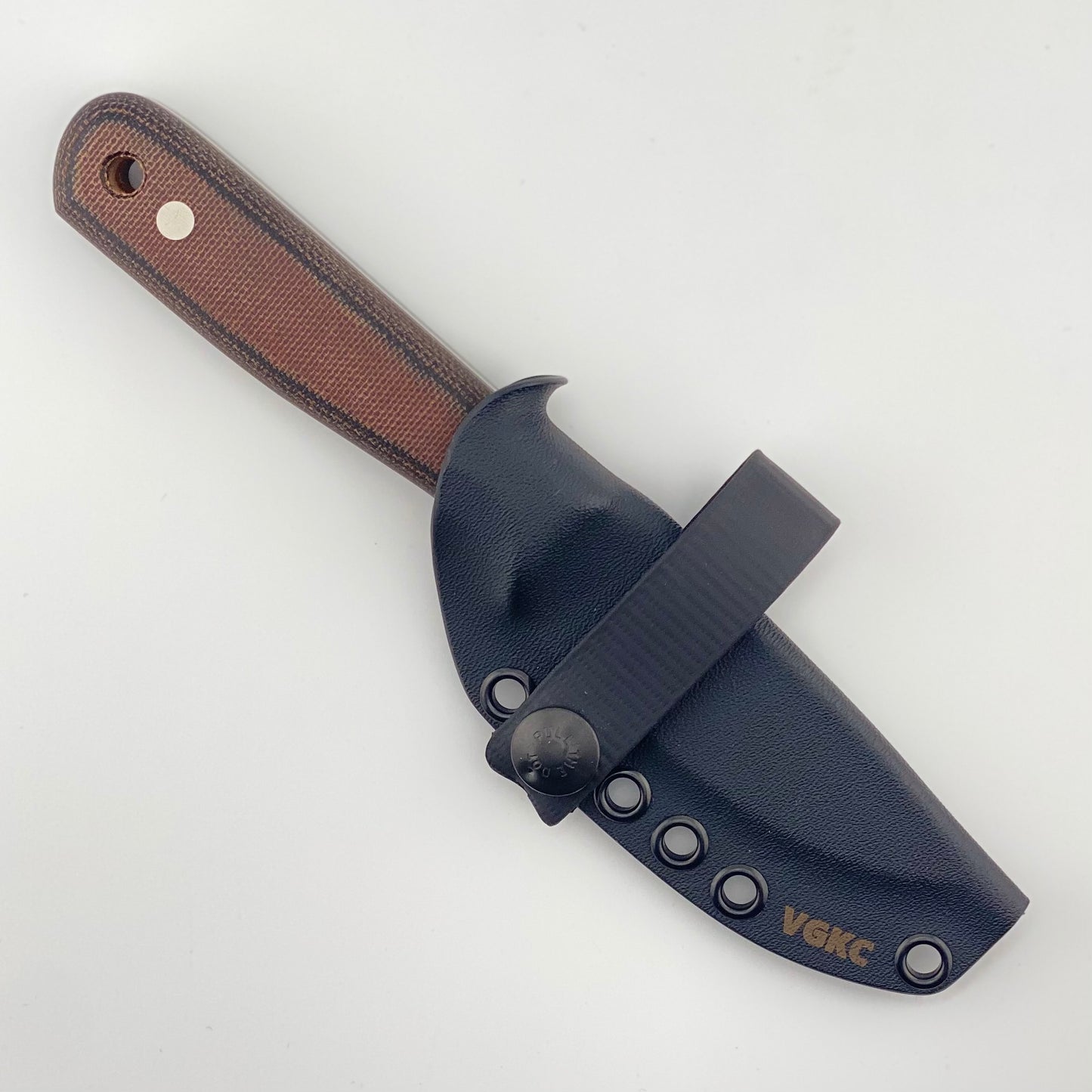 Brown and black handled knife in a black sheath on a white background
