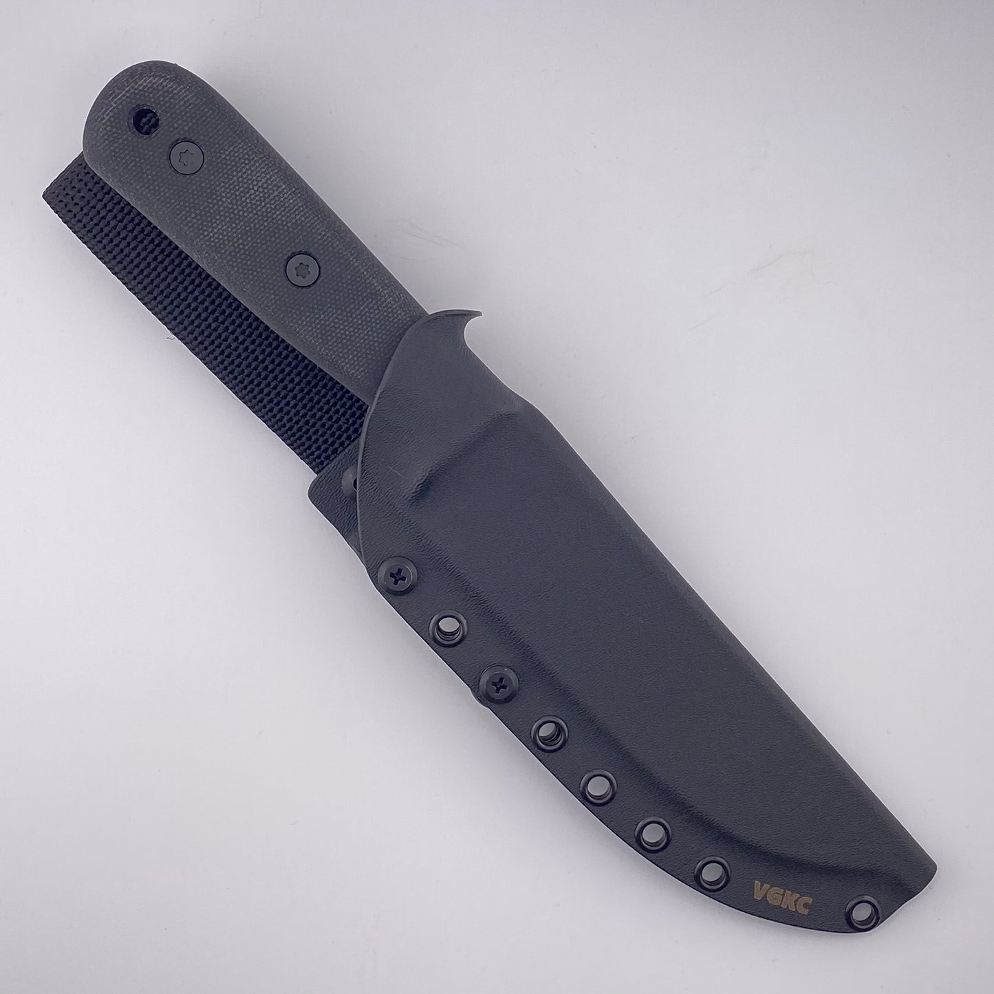 Fixed blade knife with black handles in a black sheath on a white background