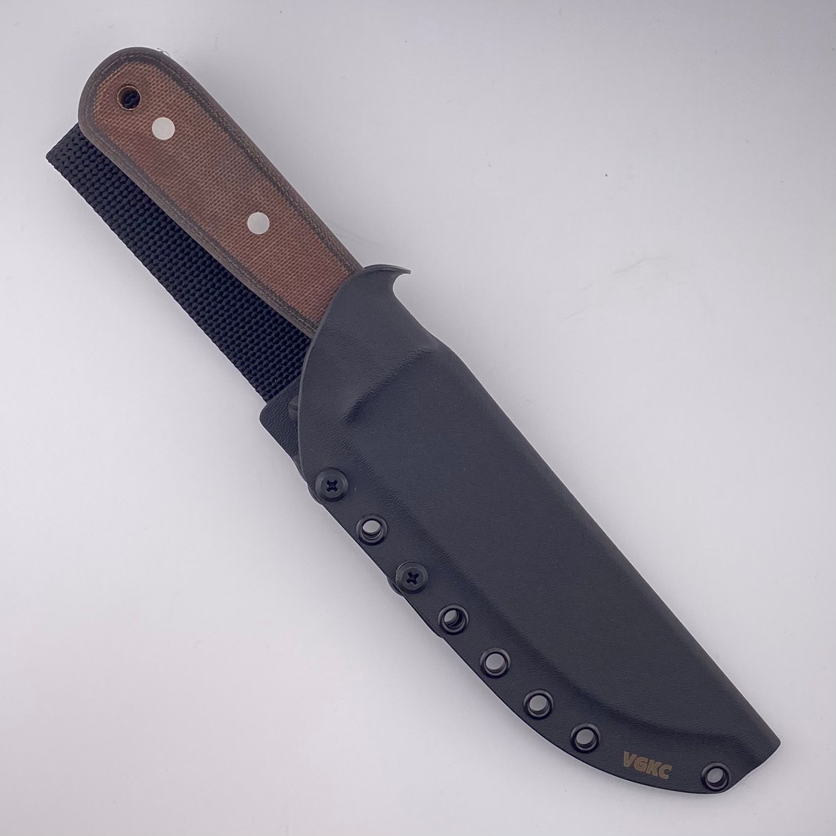 Fixed blade knife with orange and black handles in a black sheath on a white background